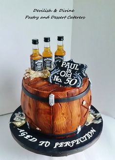 a cake made to look like a barrel with four bottles on top and a sign that says paul is no 30