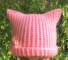 a close up of a person wearing a pink knitted hat on top of their head