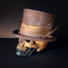 "Hides in the Cliffs" is a 56 cm ( size 7) top hat. Distressed brown, made to look worn. Handmade from Ugly Outlaw Hats. Made from lightweight Beaver fur. Features a brass colored Native American headdress with skull on the side. Wrapped with multiple leather cord and has a feather in the side. The inside has a comfortable leather sweatband. Handmade, one of a kind from Ugly Outlaw Hats. Luxury Western Wool Top Hat, Luxury Wool Western Top Hat, Luxury Western Top Hat With Flat Bill, Native American Headdress, South Pasadena, Leather Hats, Top Hat, Brass Color, Headdress