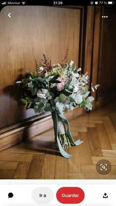 a bouquet of flowers sitting on top of a wooden floor next to a door way