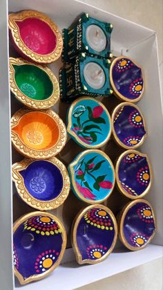 a box filled with lots of different colored bowls next to each other on top of a table