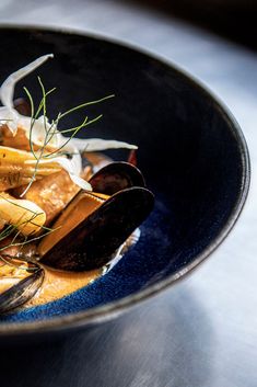 a blue bowl filled with food on top of a table