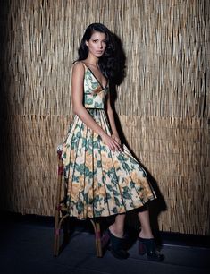 a woman standing in front of a bamboo wall