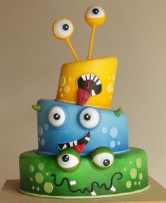 a three tiered cake with googly eyes and monster faces on it's sides