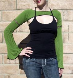 a woman standing in front of a brick wall with her hands on her hips and looking at the camera