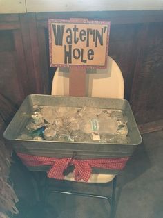 a chair with a sign that says watern'hole on it next to an ice bucket