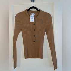 This Good American Slim Rib Polo Shirt In A Gorgeous Tan Color Is Perfect For Any Occasion. Made In Sizes 1/2 For Women, It Offers A Comfortable And Chic Way To Stay Warm. Brand: Good American Color: Tan Size: 1/3 Style: Sweater Slim-Fit Design Ribbed Texture Polo Shirt Style Features: Sweater Solid Size: Womens 1/2 Condition: Brand New With Tags Fitted Knit Top With Button Closure For Fall, Ribbed Button-up Workwear Tops, Collared Knit Top For Work In Fall, Trendy Fitted Collared Knit Top, Fitted Collared Knit Top In Trendy Style, Fitted Collared Winter Top, Fitted Collared Knit Top For Fall, Brown Ribbed Tops For Workwear, Polo Shirt Style