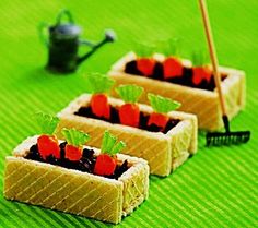 small sandwiches with carrots and blackberries in them sitting on a green tablecloth