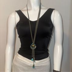 a white mannequin wearing a black top with a necklace on it's neck