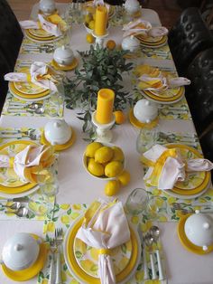 the table is set with lemons and white china plates, silverware, and napkins