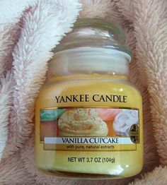 yankee candle vanilla cupcake with white chocolate frosting in jar on pink fluffy blanket