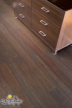 an empty kitchen with wooden floors and cabinets