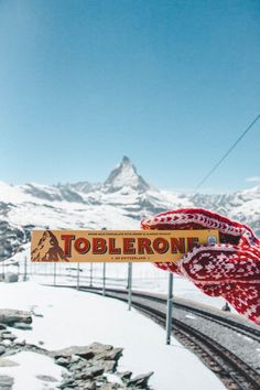 a sign that says tobleroni on it in front of a snowy mountain range