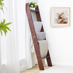 a ladder leaning up against a wall next to a bed in a room with white walls