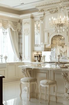 an elegant kitchen with chandelier and marble counter tops, white cabinets and stools