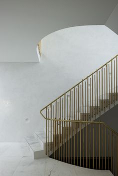 a white and gold stair case in a building