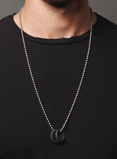 The Black Glass Two Rings Necklace for men is made from African black glass rings. Symbolic of eternity, commitment, and the love experienced between two people, these rings will fill you with a sense of time and emotion. Because of the vintage origin of the rings, now two rings/necklaces are alike and will vary slightly from the photo. Length of brass chain: 28 inches Black Stainless Steel Jewelry With Black Enamel, Round Gunmetal Stainless Steel Jewelry, Black Necklace With Oxidized Finish, Black Round Jewelry With Adjustable Chain, Black Jewelry With Adjustable Round Chain, Minimalist Black Metal Jewelry, Black Metal Ring Jewelry As A Gift, Black Metal Ring Jewelry For Gifts, Black Metal Ring Jewelry Gift