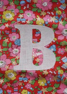 the letter b is made out of fabric and has flowers all over it's surface