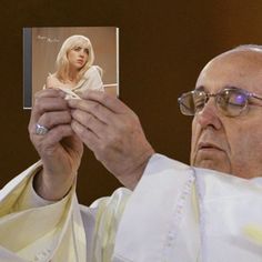 a man holding up a photo of a woman in front of him with her hands