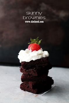 a stack of brownies with whipped cream and a strawberry on top