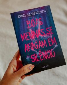 a person holding up a book with the title boas mennesse arogam em silencio