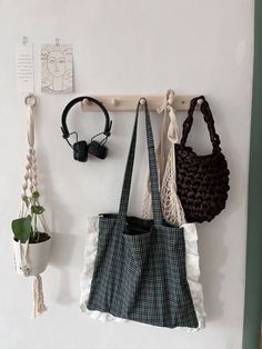 three purses hanging on the wall next to each other with headphones and earbuds