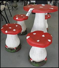 three red and white mushroom stools sitting next to each other in a room filled with tables and chairs