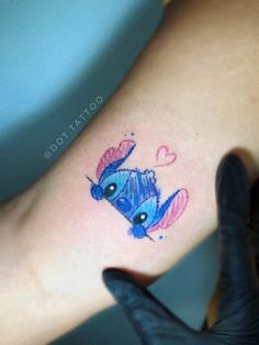 a small tattoo on the foot of a woman's leg with an image of a blue bird