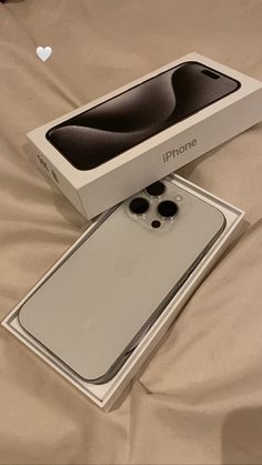 an iphone box sitting on top of a bed next to it's opened packaging