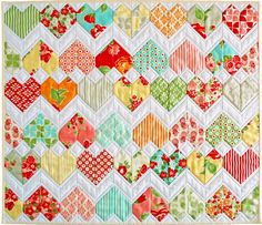 the quilt is made up of many different colors and shapes, including red, green, yellow