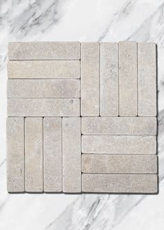 several pieces of white marble sitting on top of each other in the middle of a tile floor