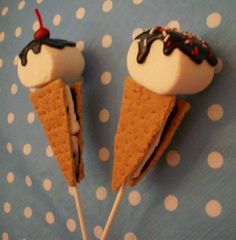 two ice cream cones with toppings are on a polka dot tablecloth, one is white and the other is brown