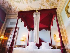 the canopy bed is made up with white linens