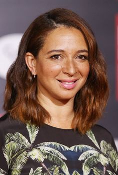 a close up of a person wearing a shirt with palm trees on it and smiling at the camera