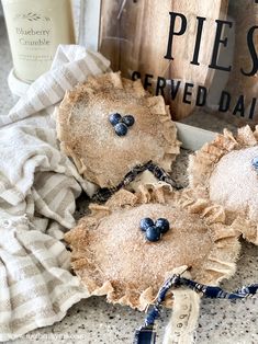 three pieces of fabric with blueberries on them sitting next to a sign and some other items