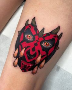 a woman's leg with a tattoo on it that has an image of a demon