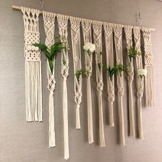 macrame wall hangings with white flowers and greenery on the top one