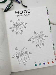 an open notebook with drawings on it and the words mood drawn in black ink next to scissors