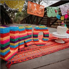 a cake on a table with colorful decorations hanging from it's sides and the word love spelled out in large letters