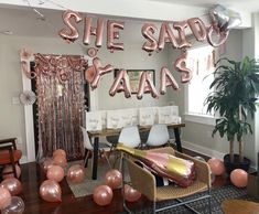 a party room with balloons and streamers in the shape of letters that read she said yaas