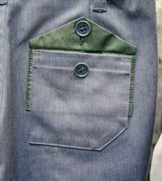 a pair of blue pants with buttons on the side and one button in the pocket