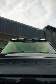 an suv is parked in front of a building with two lights on it's roof