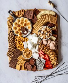 a platter filled with different types of snacks and desserts on top of a marble table