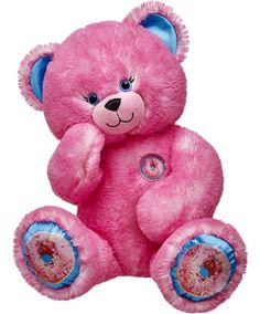 a pink teddy bear sitting on top of a black background with blue eyes and ears