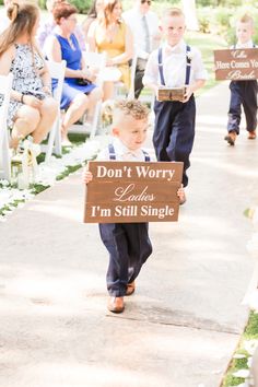 two young boys walking down a sidewalk holding signs that say don't worry unless i'm still single