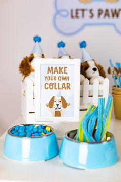 a dog themed birthday party with blue and white decorations on the table, including a sign that says make your own collar