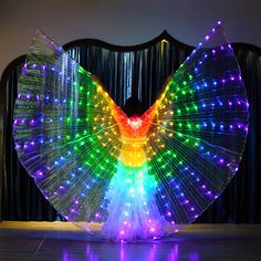 a colorful light up bird with wings on the dance floor in front of a curtain