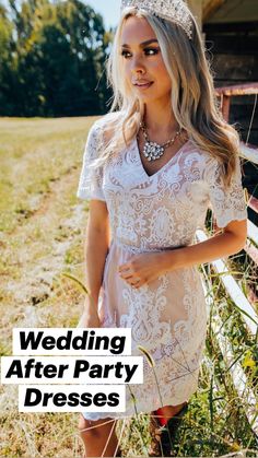 a woman wearing a tiara standing in front of a fence with grass and flowers