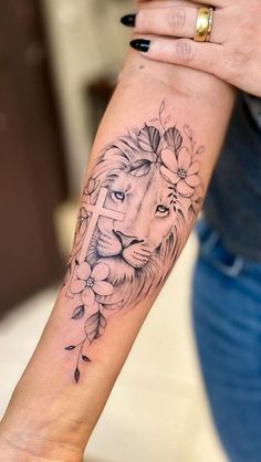 a woman's arm with a lion and flowers tattoo on the left side of her arm