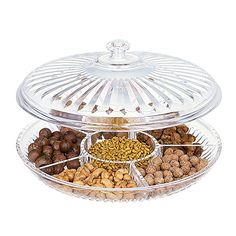 an assortment of nuts and cereals in glass dishes on a platter with lid